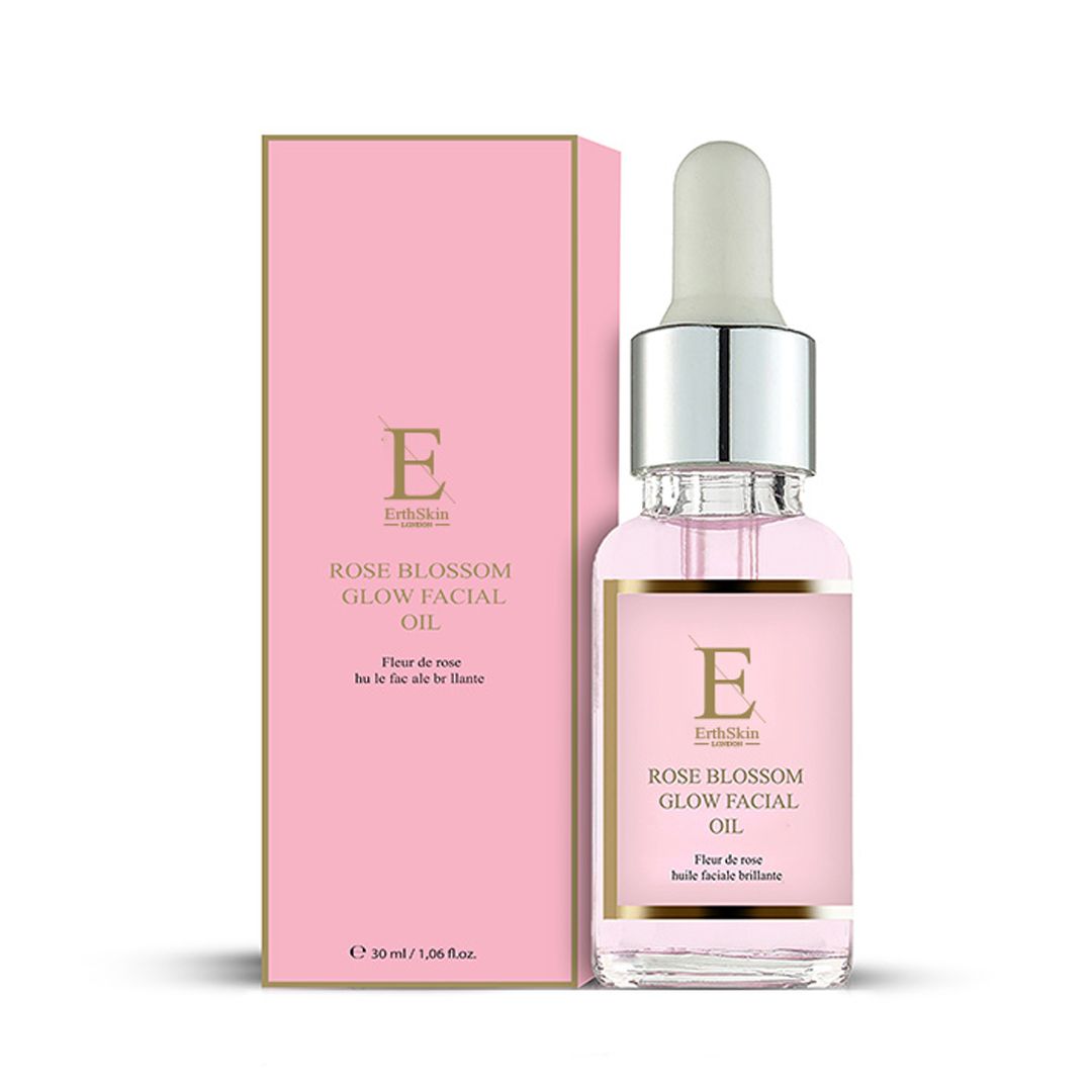 Glazen fles met druppelaar en roze productdoos. Etiket toont 'Rose Blossom Glow Facial Oil'.