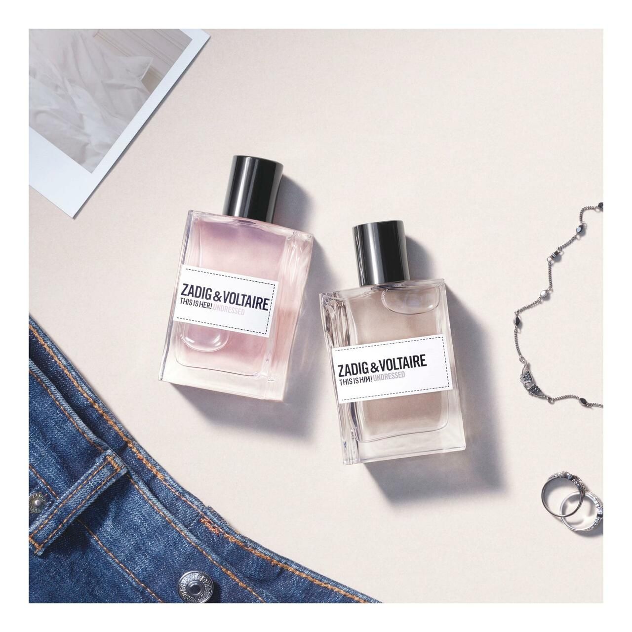 Zadig & Voltaire This is Him! Undressed EdT Nat. Spray. Twee flacons op lichte achtergrond. Jeans en accessoires.