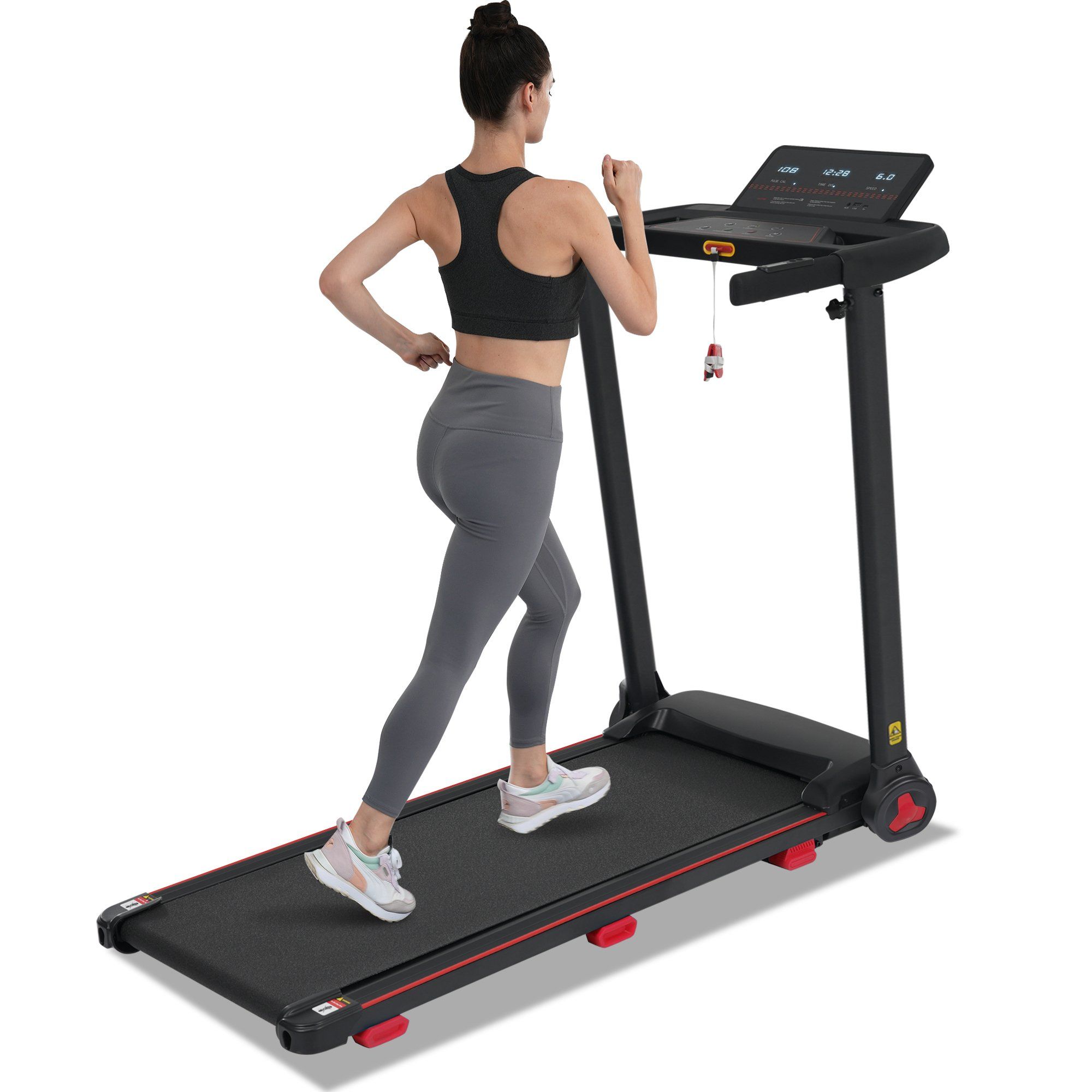 Tapis roulant pliable noir avec accent rouge, vu de côté par une femme.