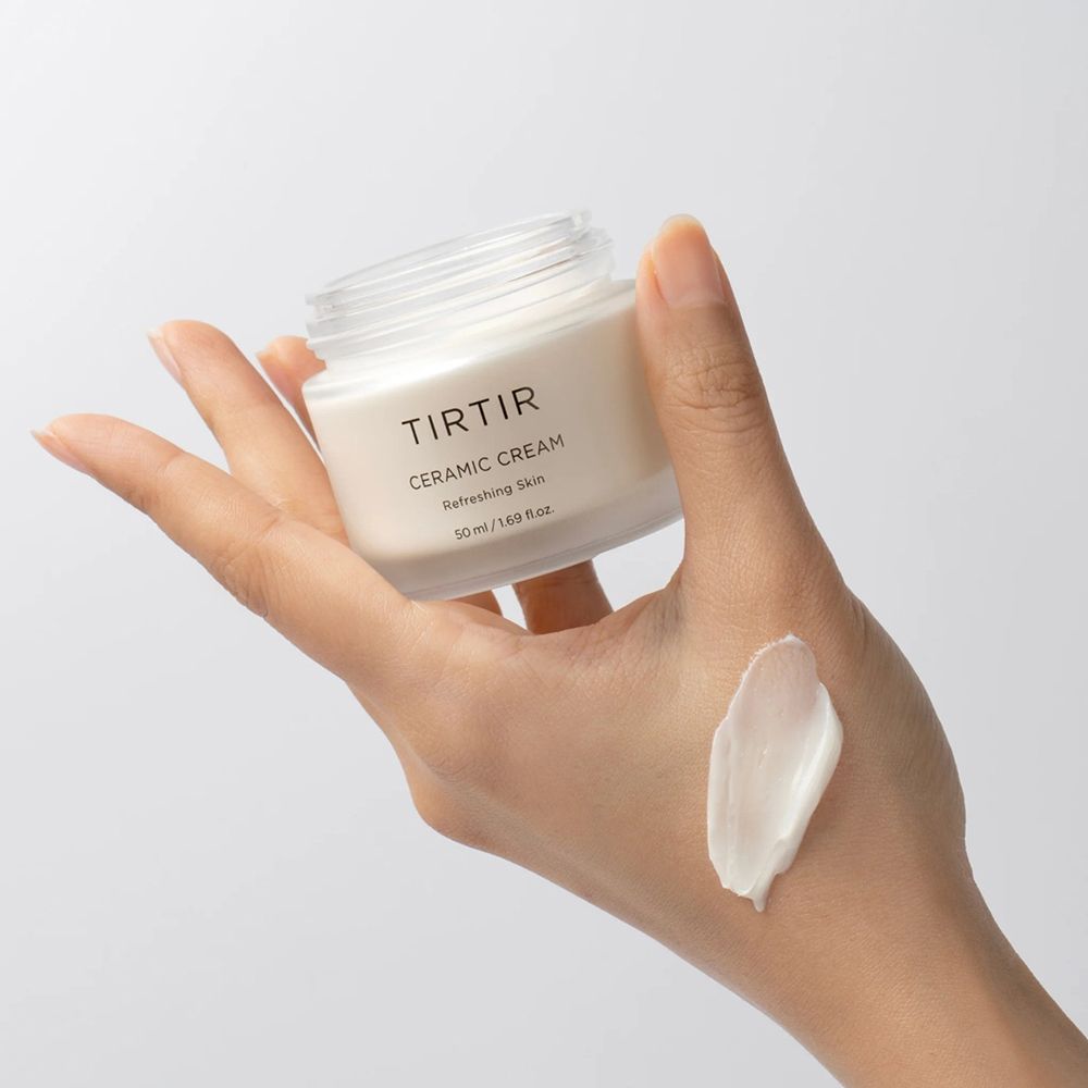 Hand houdt een open pot Tir Tir Ceramic Cream en een klodder crème vast. Opschrift: Ceramic Cream, Refreshing Skin, 50 ml.