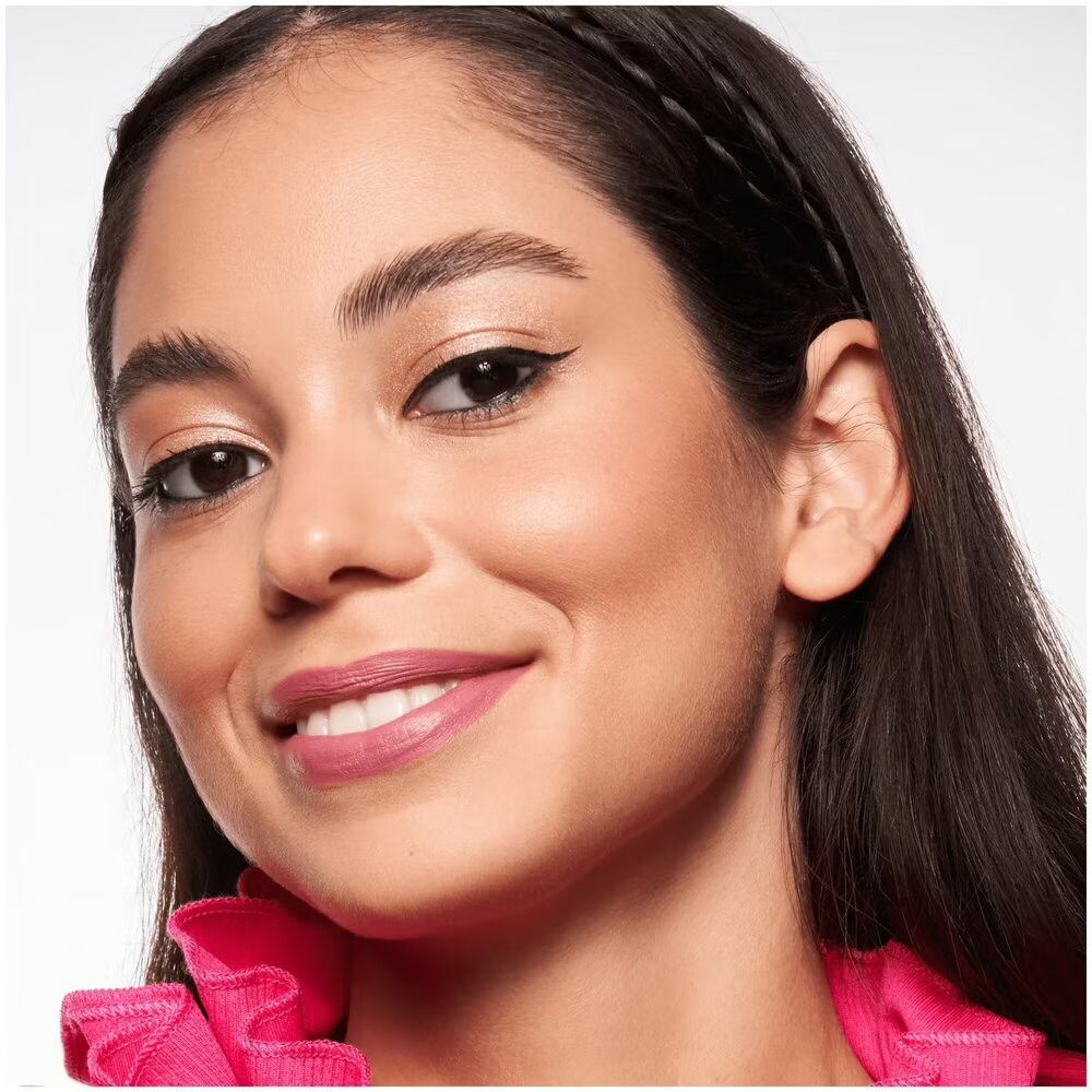 Close-up van een vrouw met blush op de wangen. Donker haar, gevlochten. Glimlach.