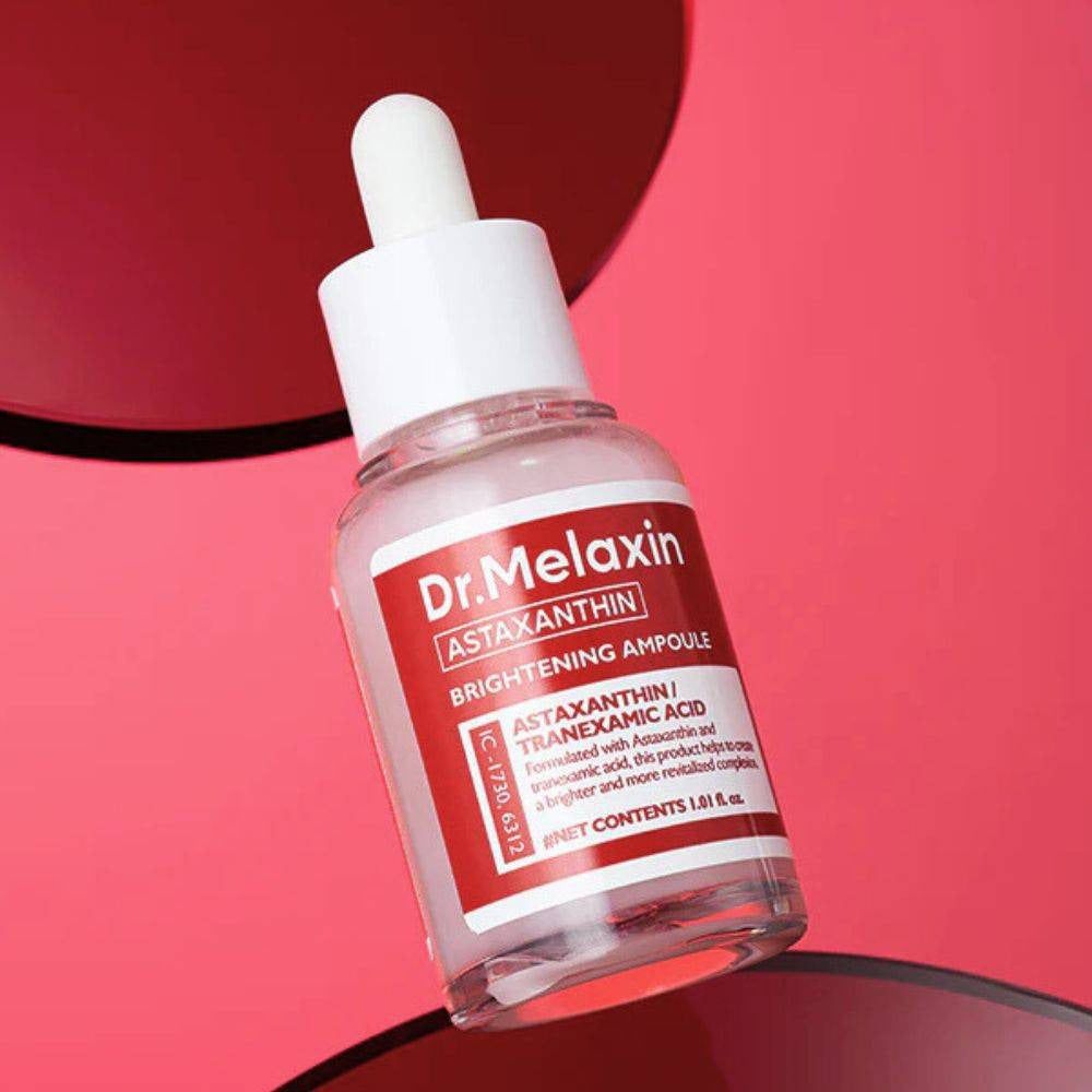 Flacon en verre transparent avec bouchon blanc et étiquette rouge. Texte: Dr. Melaxin, Astaxanthine, Brightening Ampoule. Compte-gouttes.