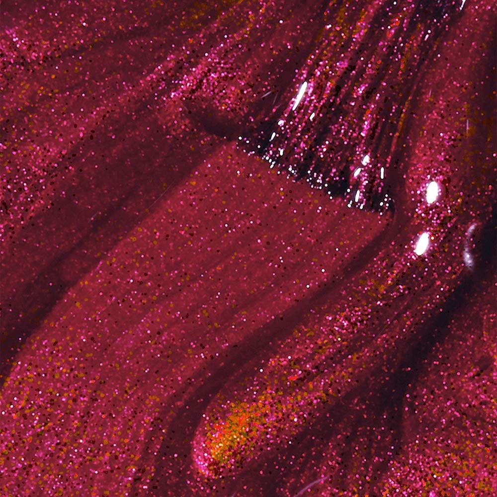 Nagellakstaal met penseel. Donkerrode lak met glitterdeeltjes. Penseelstreken zichtbaar.