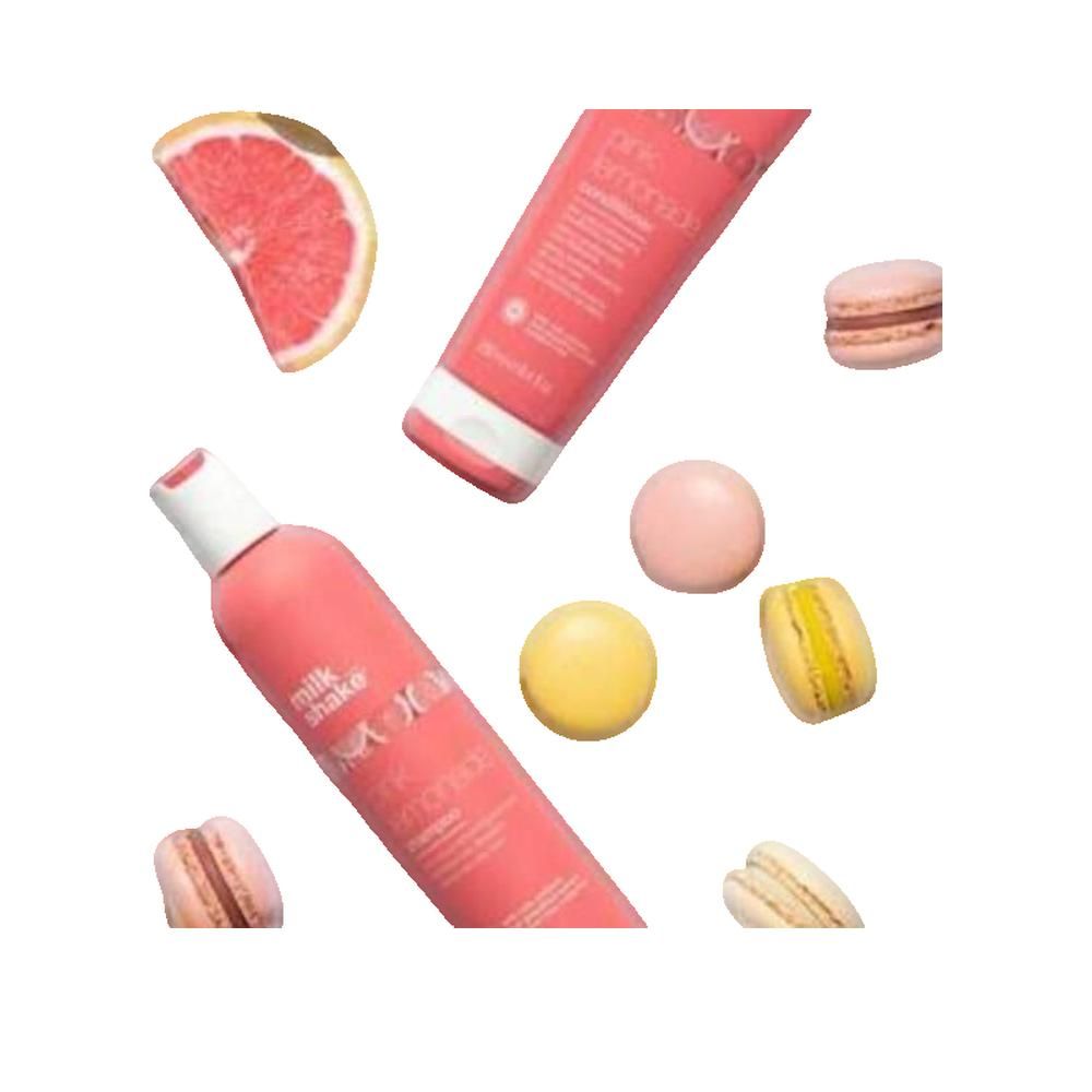 Roze fles en tube met productnamen. Merk Milk Shake. Pink Lemonade shampoo en conditioner. Macarons en grapefruit.