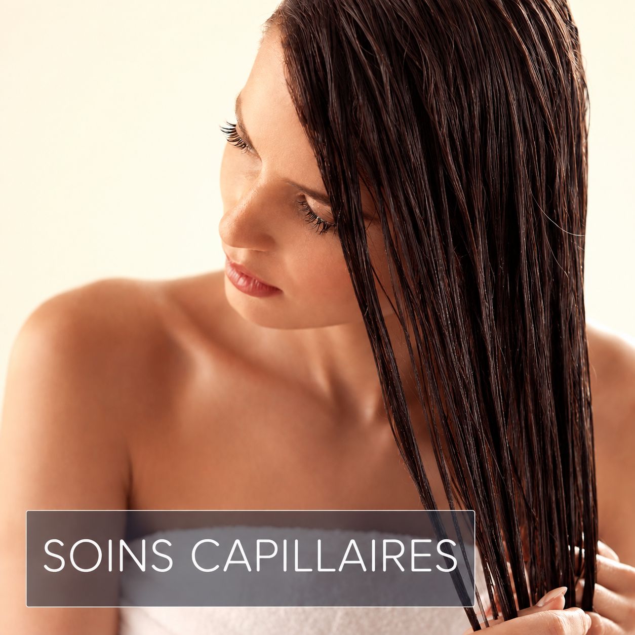 Femme aux cheveux bruns et mouillés, s'occupant de sa chevelure.