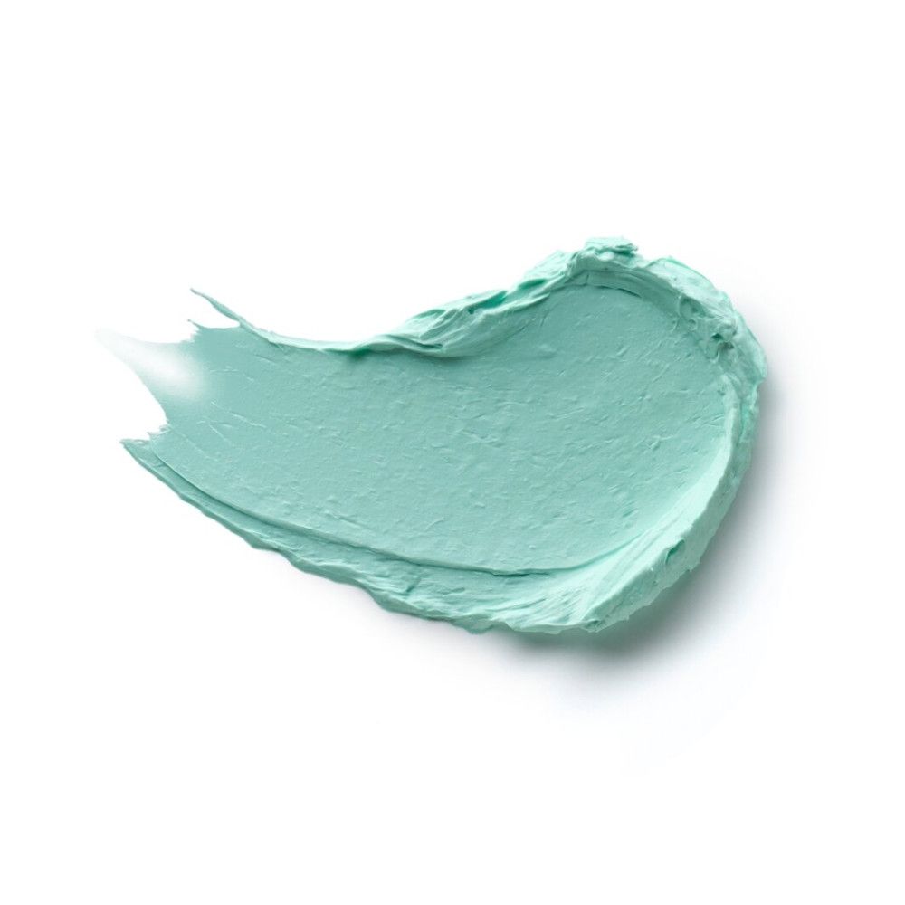 Veeg van lichtgroene mascara primer op witte achtergrond.