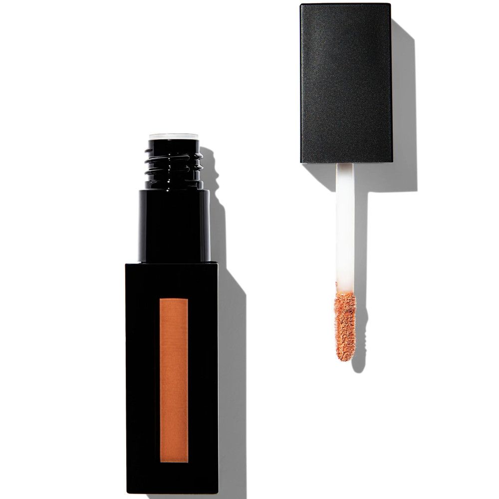 Tube de gloss noir rectangulaire avec bouchon ouvert et applicateur. L'applicateur a une pointe claire avec du produit orange.
