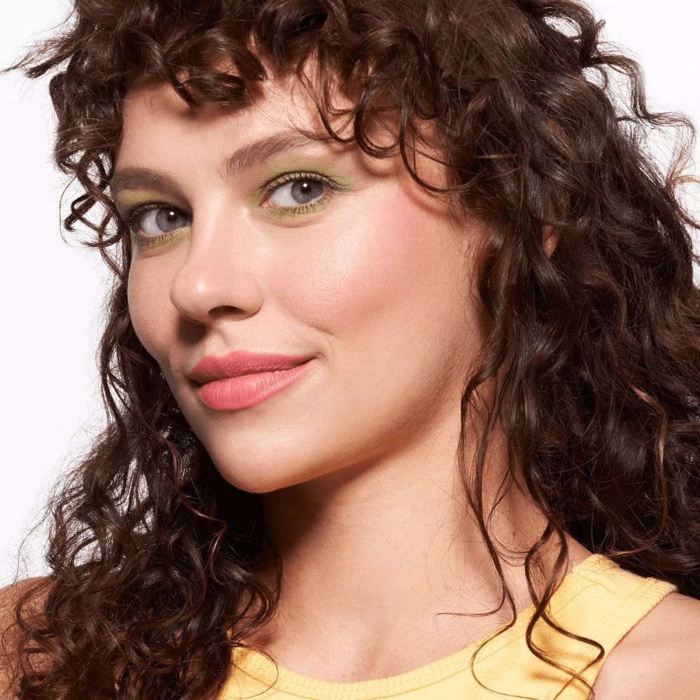 Portret van een vrouw met make-up. Groene oogschaduw, roze lippenstift.