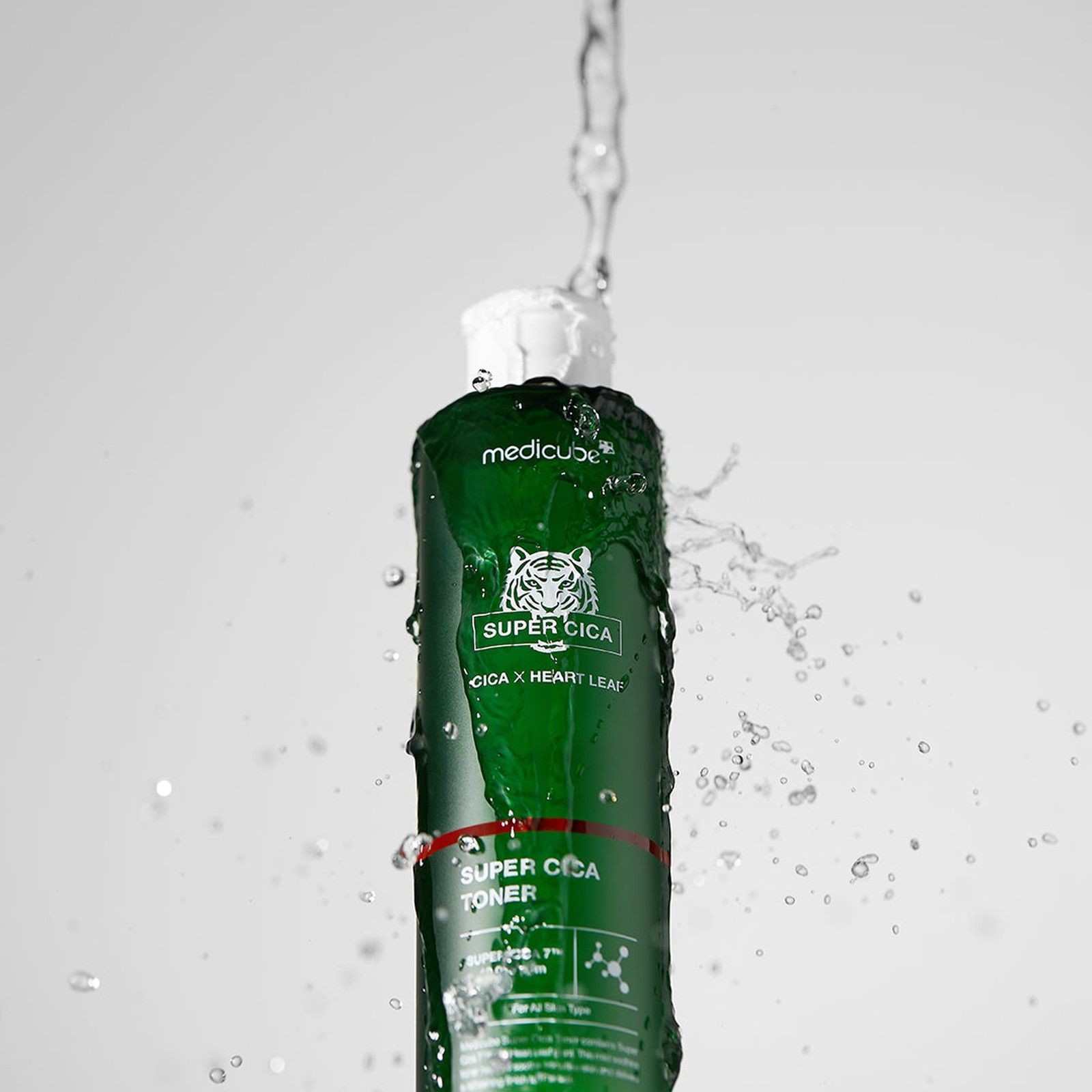 MEDICUBE Super Cica Toner fles omgeven door waterspetters.