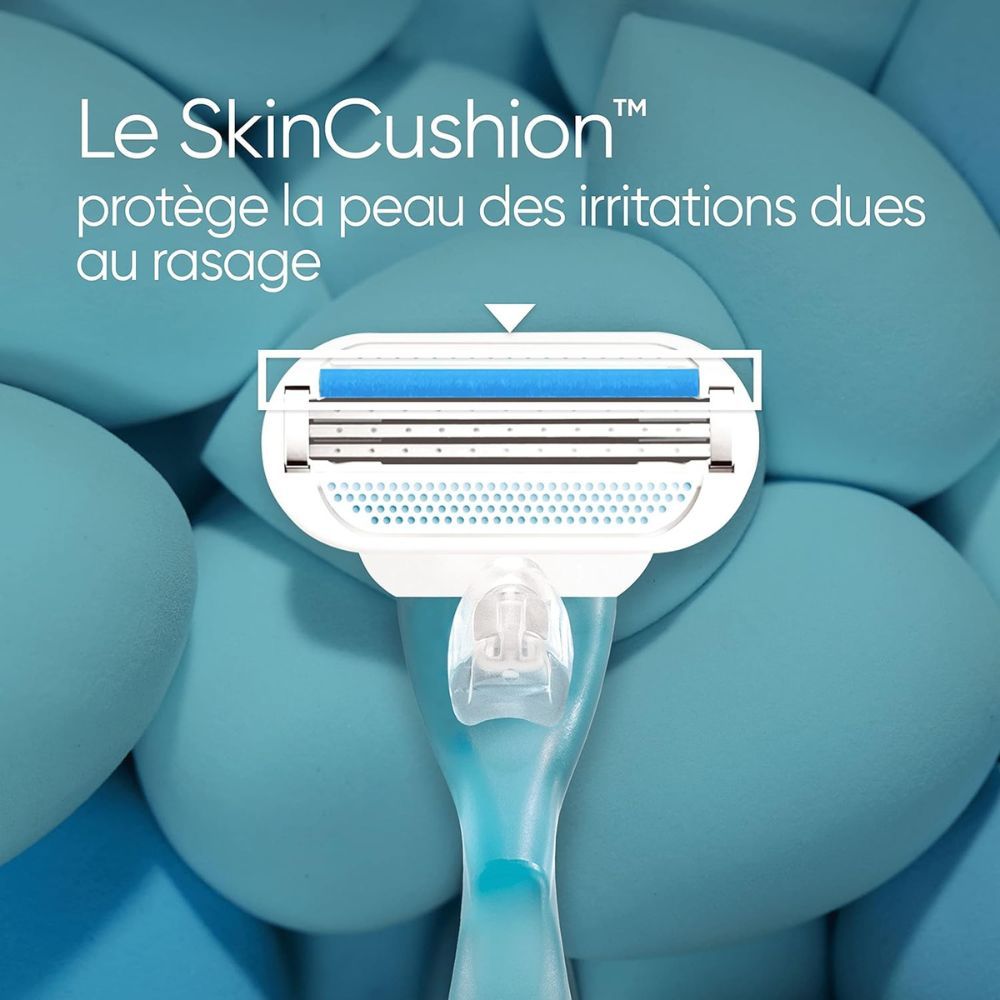 Gros plan sur le rasoir. 3 lames, technologie SkinCushion. Bleu et blanc. Fond: formes en mousse bleues.