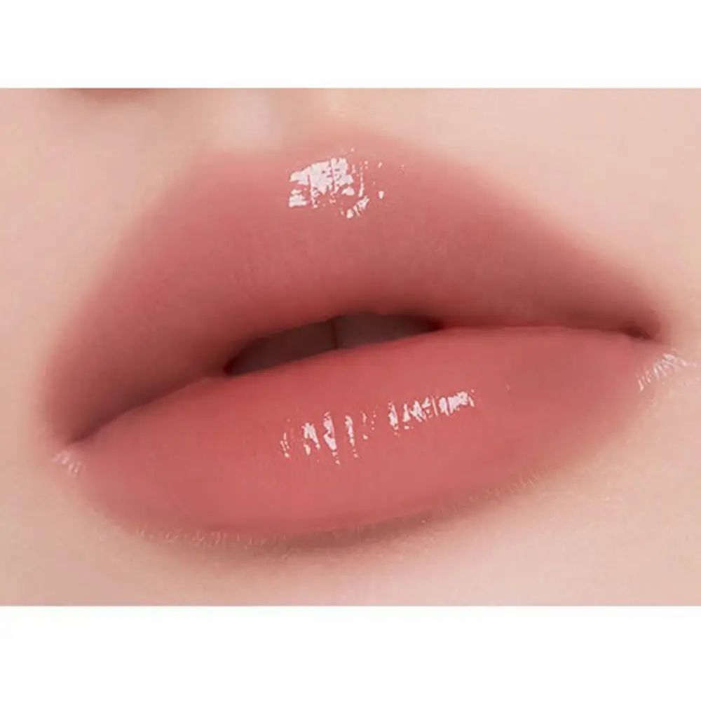 Close-up van lippen met glanzende lip tint. De lippen zijn roze en glanzend.
