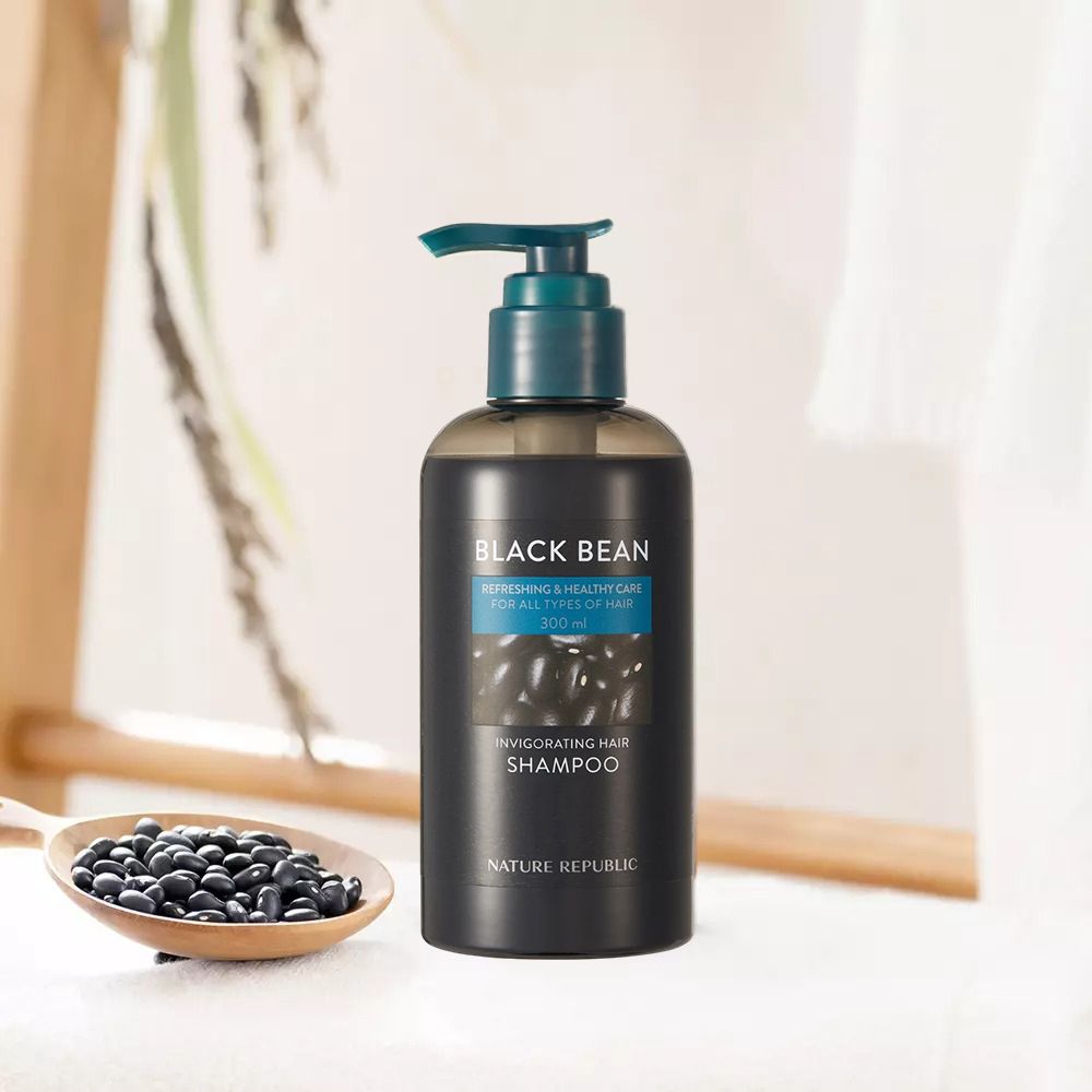 Flacon de shampooing noir avec pompe. Texte : Black Bean, Invigorating Hair Shampoo, Nature Republic. Haricots noirs dans une cuillère en bois.