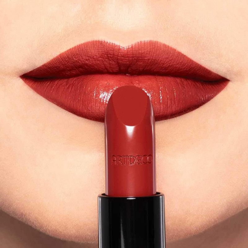 Rode lipstick aangebracht op volle lippen. ARTDECO logo op de lipstick.
