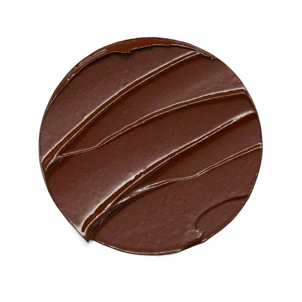 Échantillon de bronzer brun circulaire sur fond blanc.