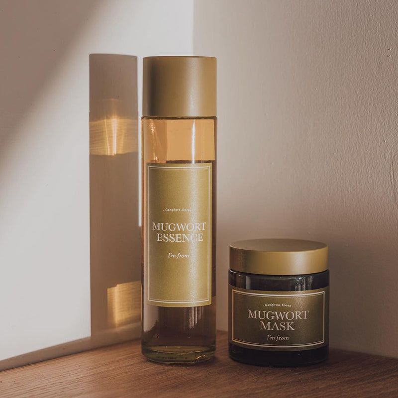 Glazen fles en glazen pot met "Mugwort Mask" etiket. Op een houten oppervlak.