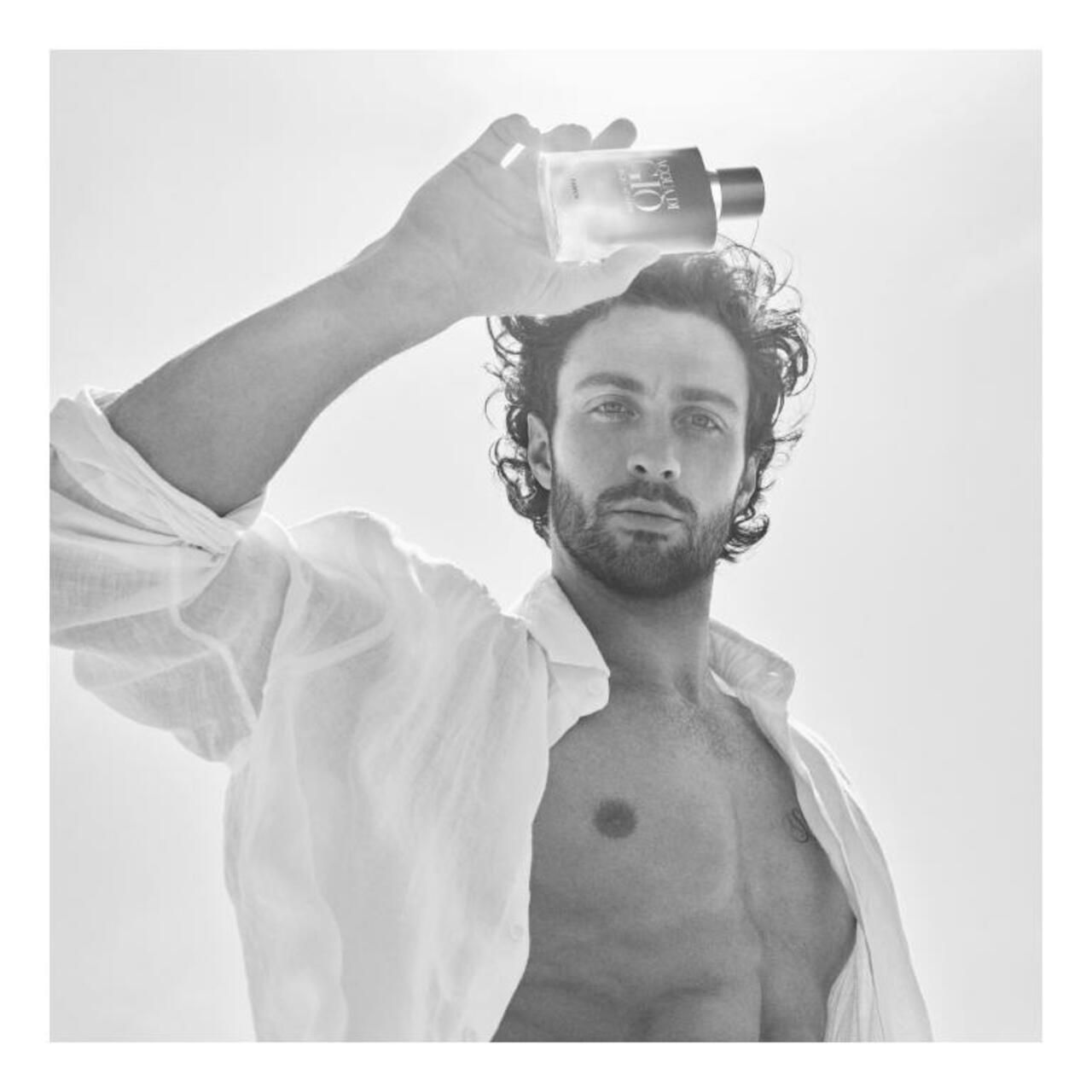 Zwart-wit foto. Man houdt fles boven zijn hoofd. ACQUA DI GIO PROFONDO zichtbaar.