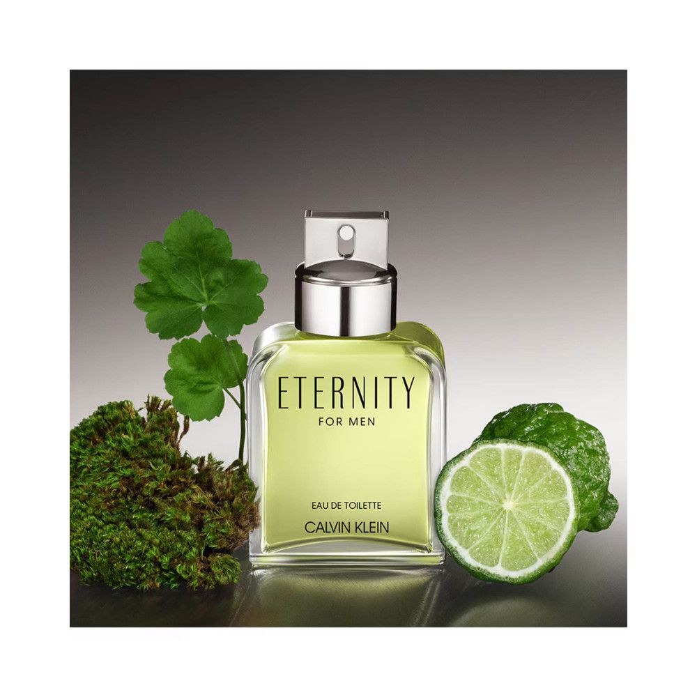 Flacon avec bouchon argenté, à côté de feuilles vertes, de mousse et d'une tranche de citron vert. Inscription: ETERNITY FOR MEN, Eau de Toilette, CALVIN KLEIN.