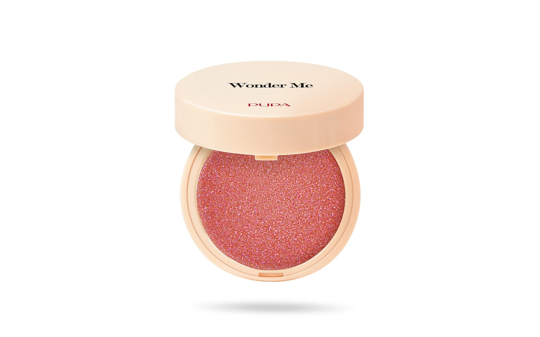 Ronde, open blush-container. Deksel met opschrift Wonder Me. Roze poeder binnenin.