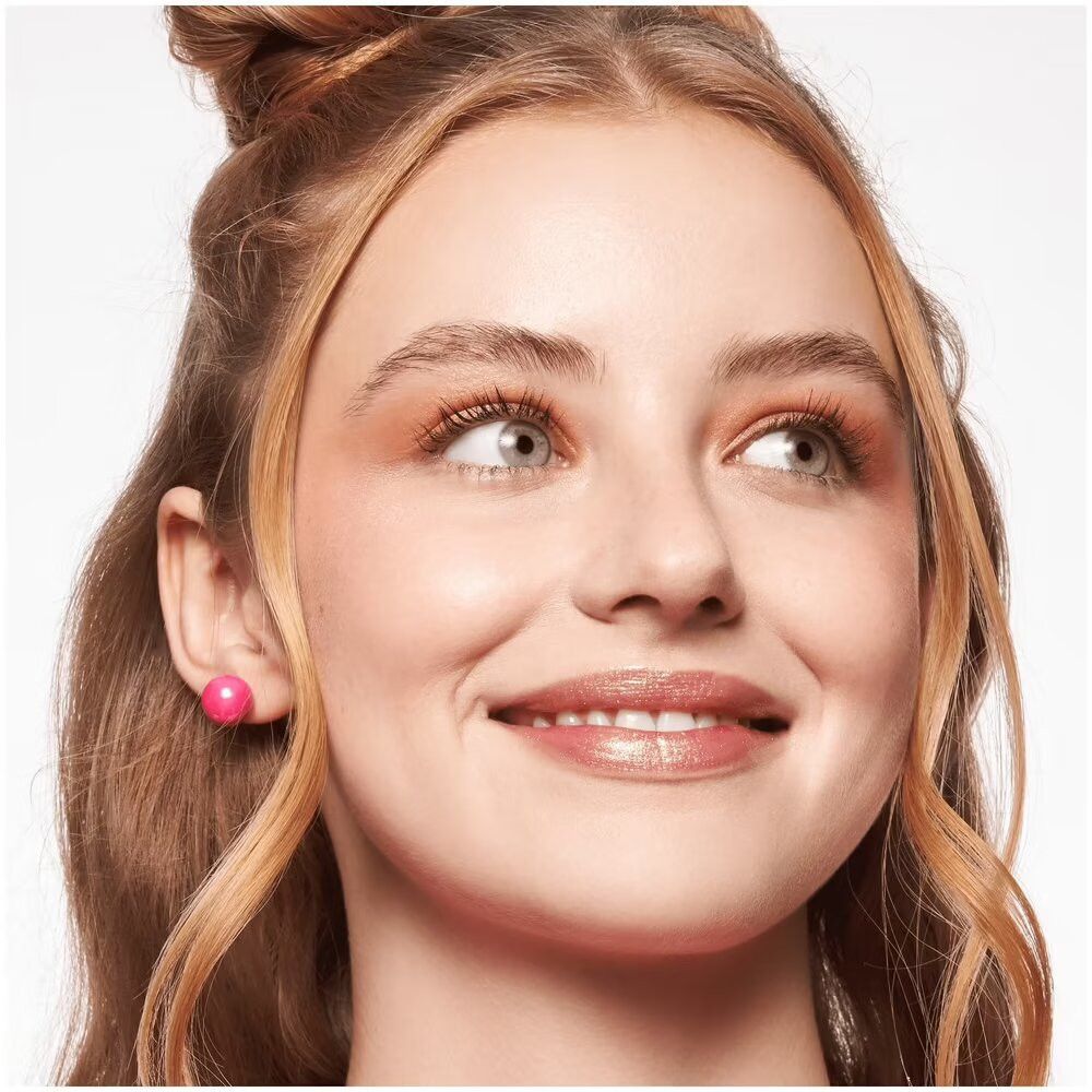 Portret van een vrouw met blush op de wangen. Opgestoken haar. Oorbellen. Glimlach.