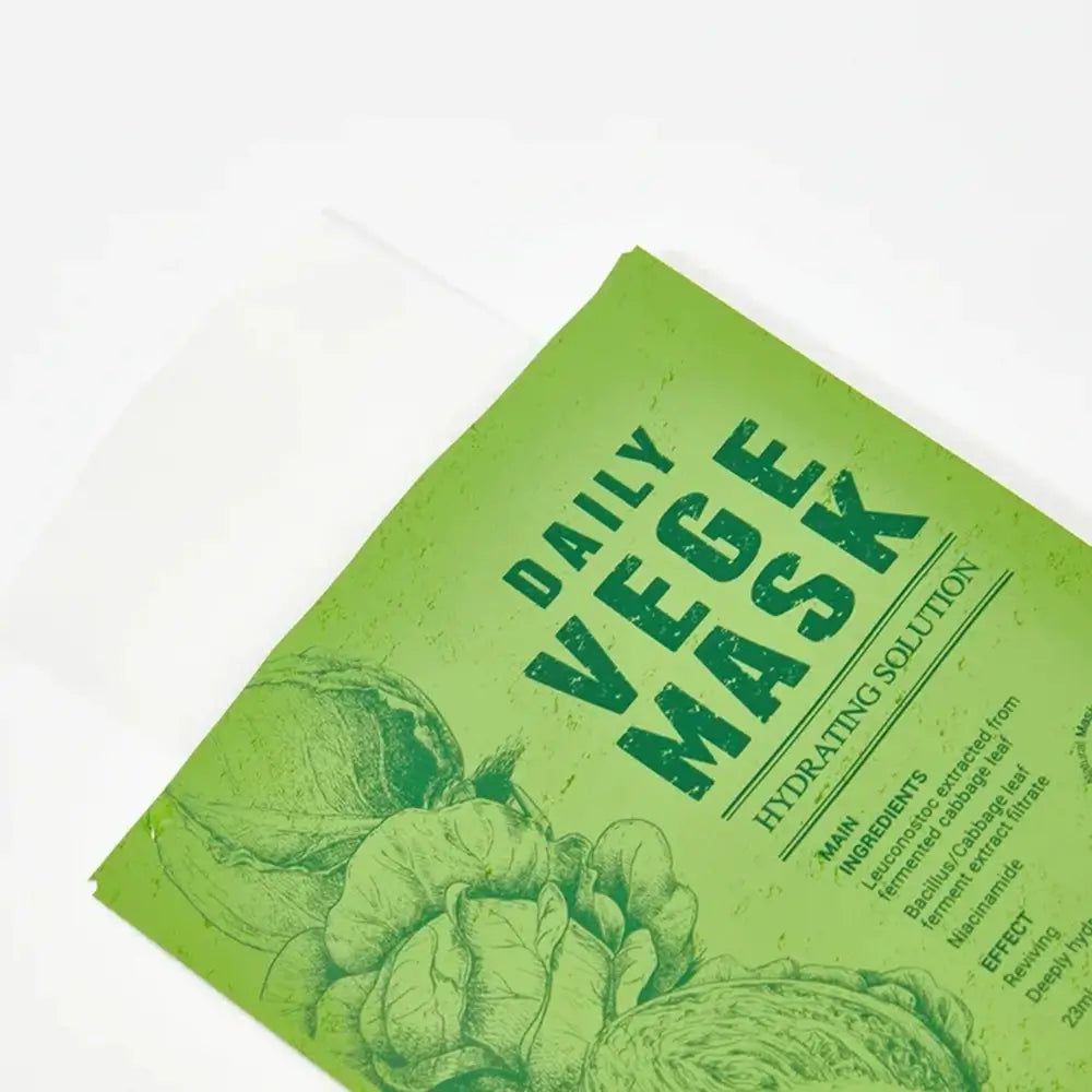 Groen gezichtsmasker met opdruk "DAILY VEGE MASK". Belangrijkste ingrediënten en componenten bedrukt. Afdruk van groente-illustraties.