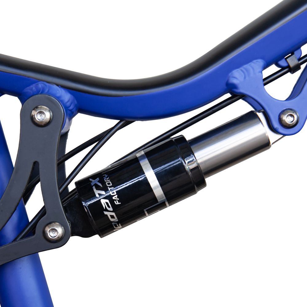 Gros plan de l'amortisseur d'un VTT électrique bleu. Inscription HedaTX Factory.