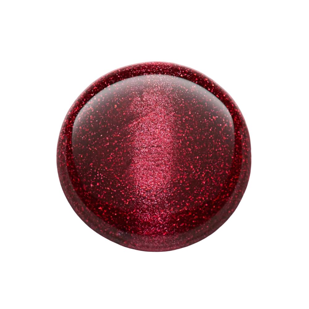 Tache ronde de vernis à ongles rouge-brun avec paillettes. Le vernis est brillant.