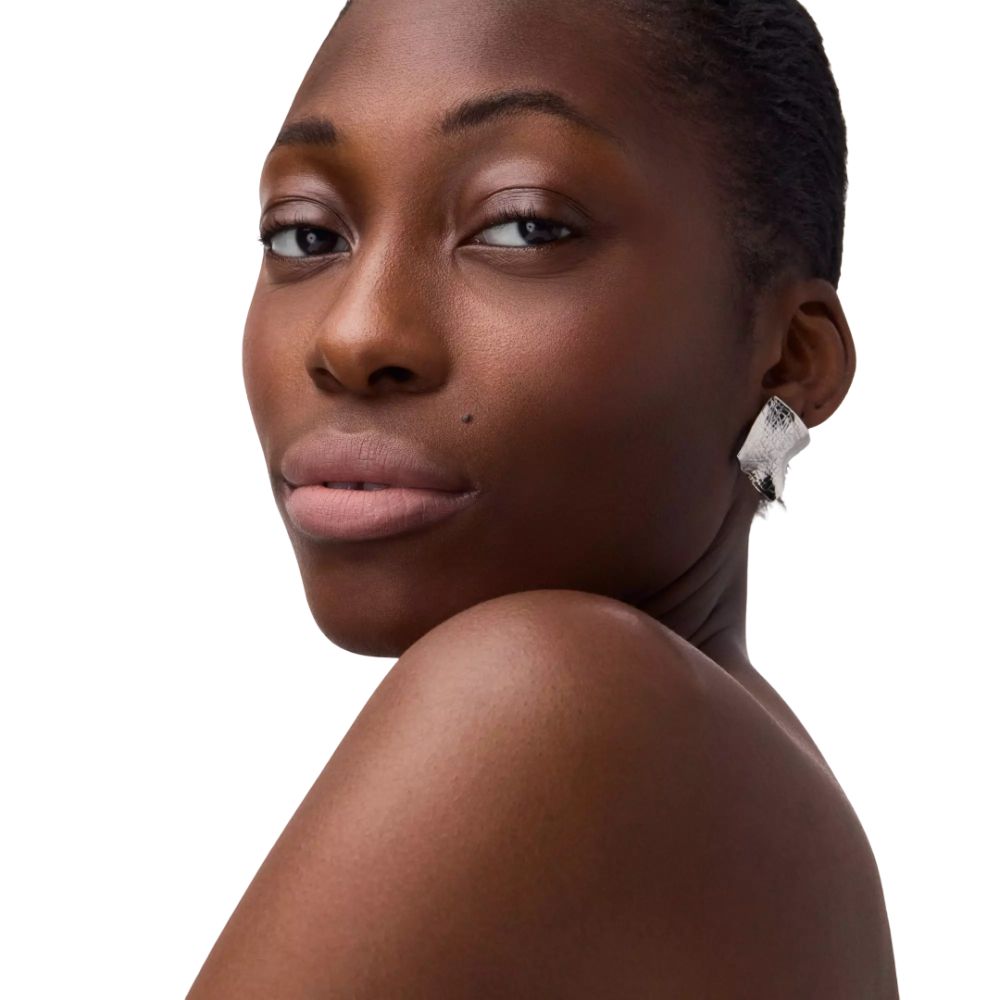Portrait d'une femme avec du rouge à lèvres. Rouge à lèvres nude. La femme porte une boucle d'oreille argentée.