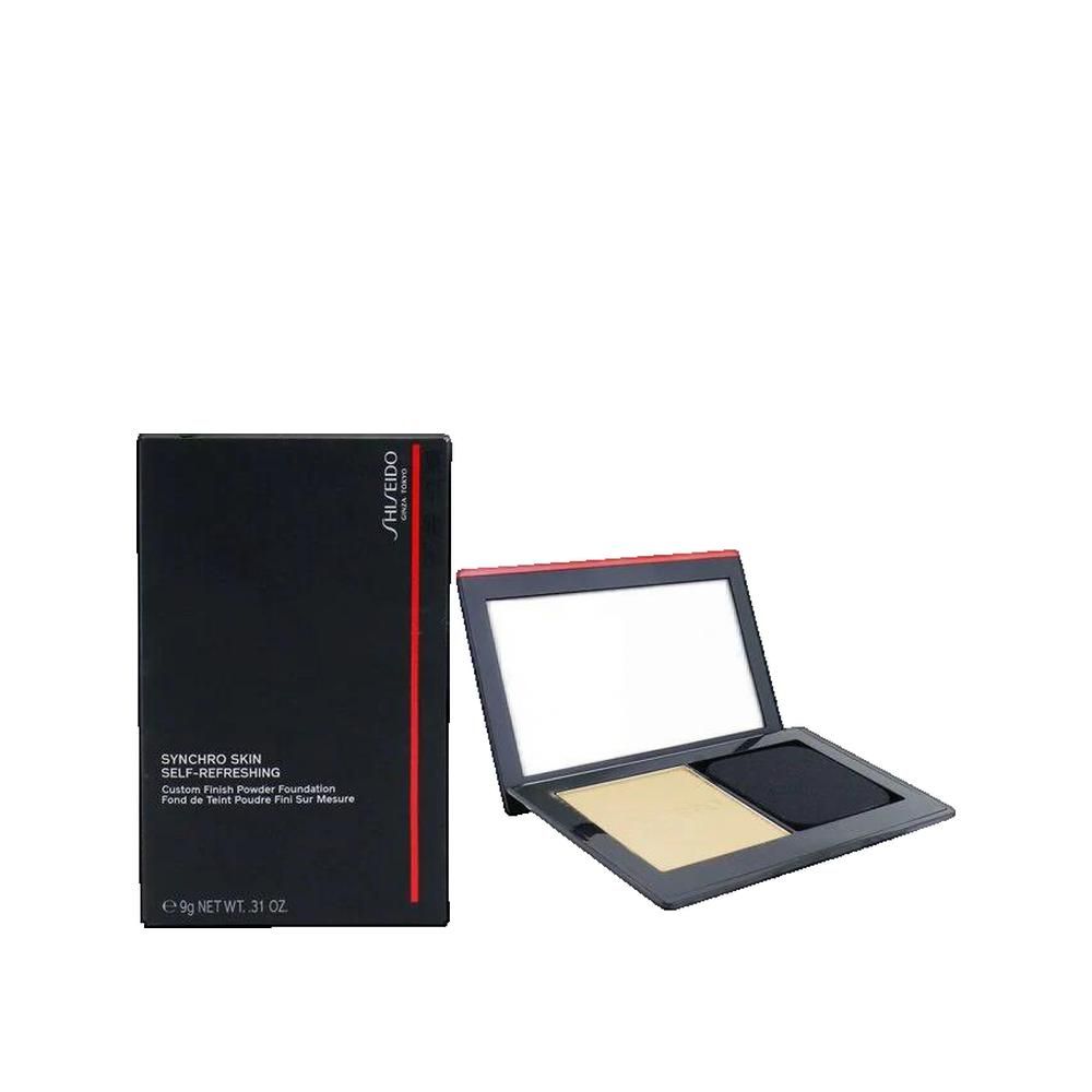Poudre compacte et emballage. Emballage noir avec accent rouge. Logo Shiseido.