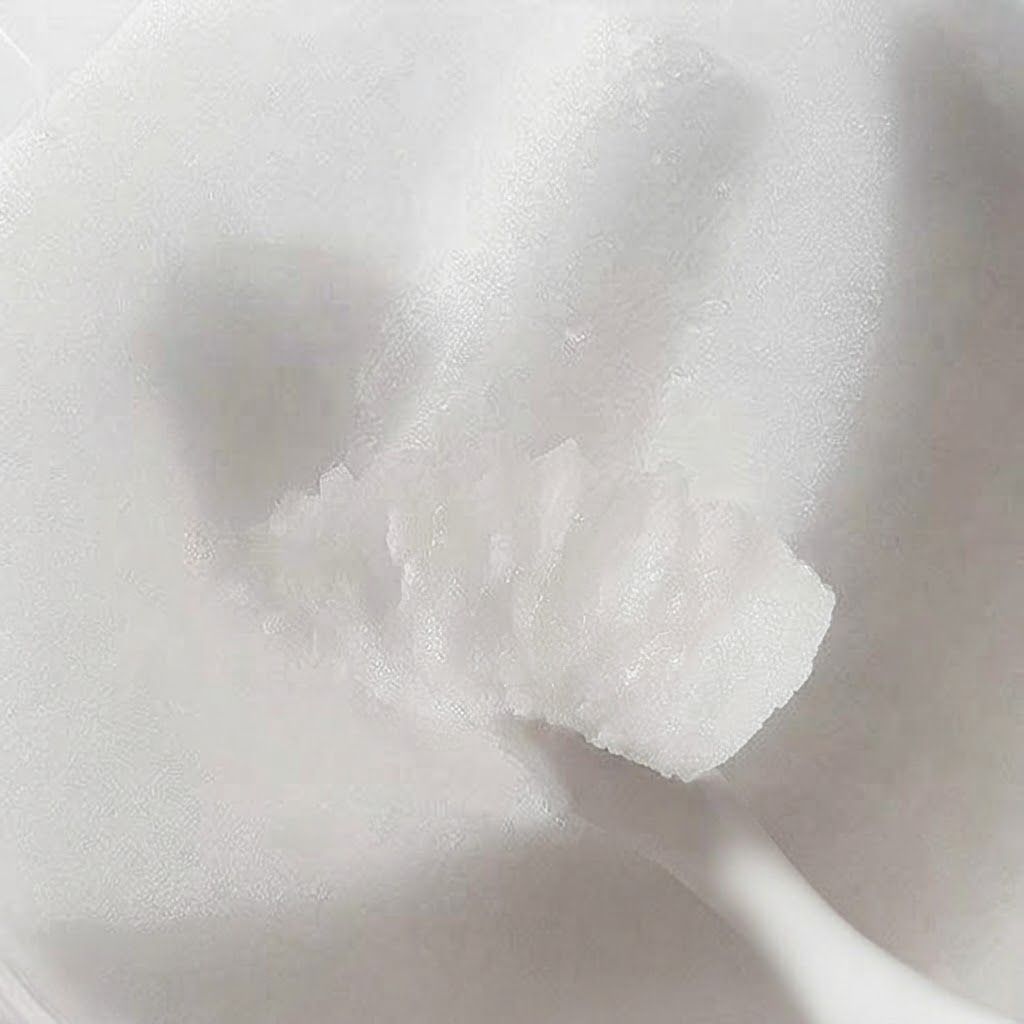 Texture de baume nettoyant sur une spatule blanche.