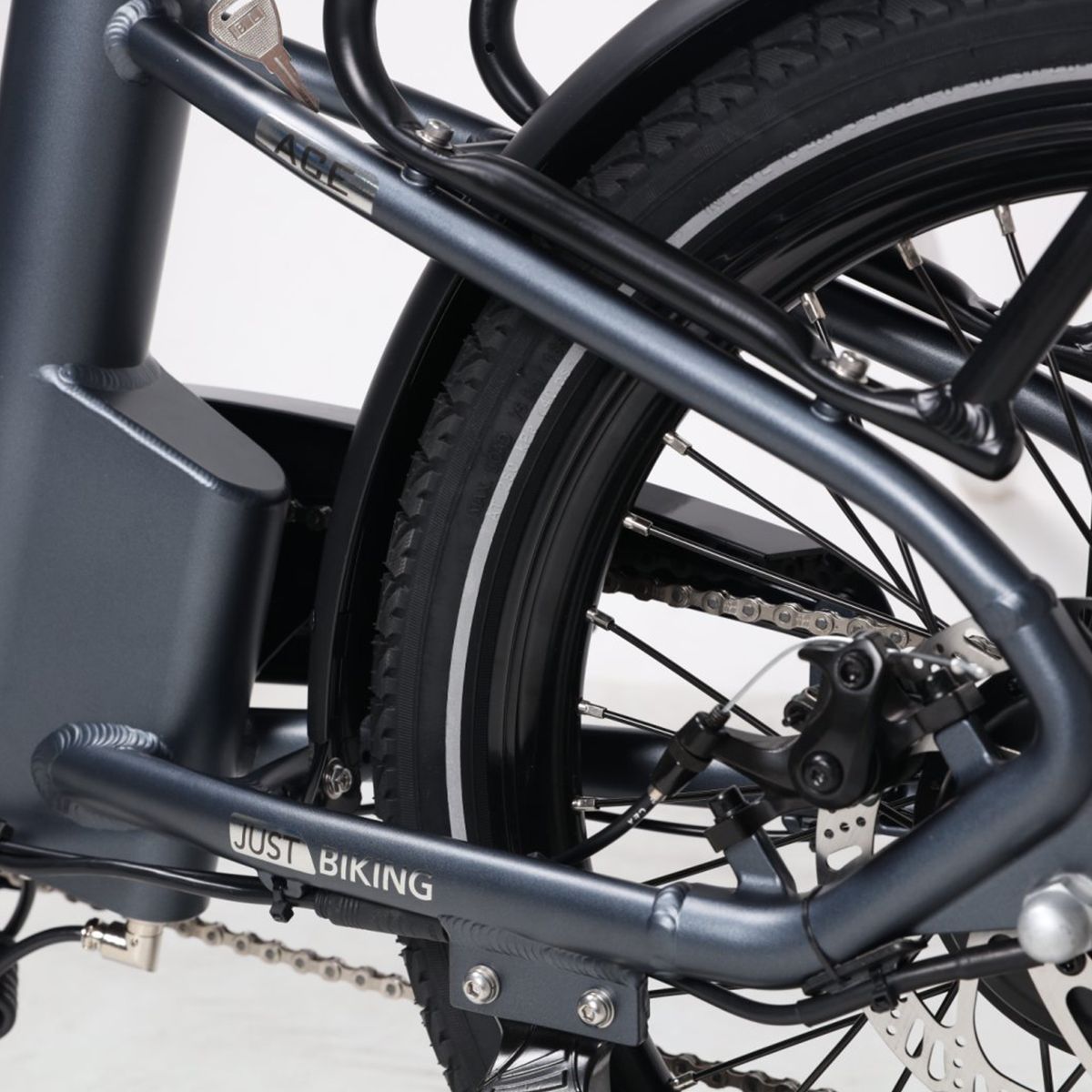 E-bike frame met JUST BIKING-opschrift. Grijze kleur, bagagedrager en achterrem.