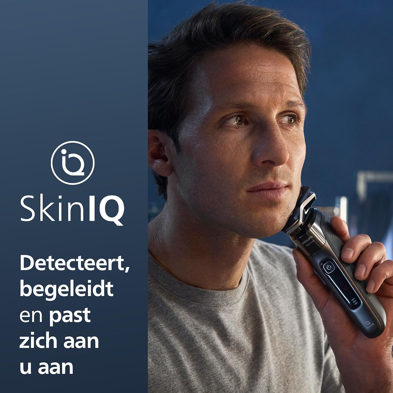 Een man scheert zich met een elektrische scheerapparaat met SkinIQ-technologie. Het scheerapparaat is zwart en zilverkleurig met een digitaal display.