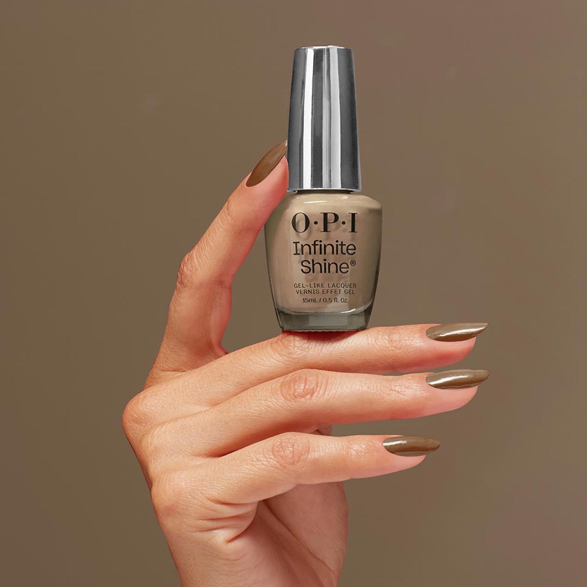 Bouteille de vernis à ongles OPI Infinite Shine taupe, tenue par une main avec le vernis assorti.