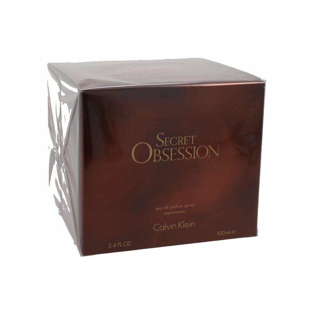 Bruine vierkante verpakking met "Secret Obsession" en "Calvin Klein". Opschrift 3.4 FL OZ en 100 ml.