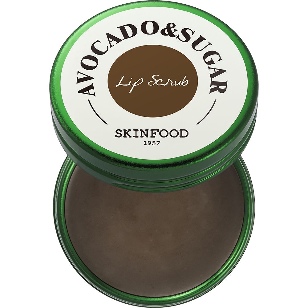 Groene pot met open deksel. Bruine inhoud zichtbaar. Opschrift: AVOCADO & SUGAR, Lip Scrub, SKINFOOD 1957.
