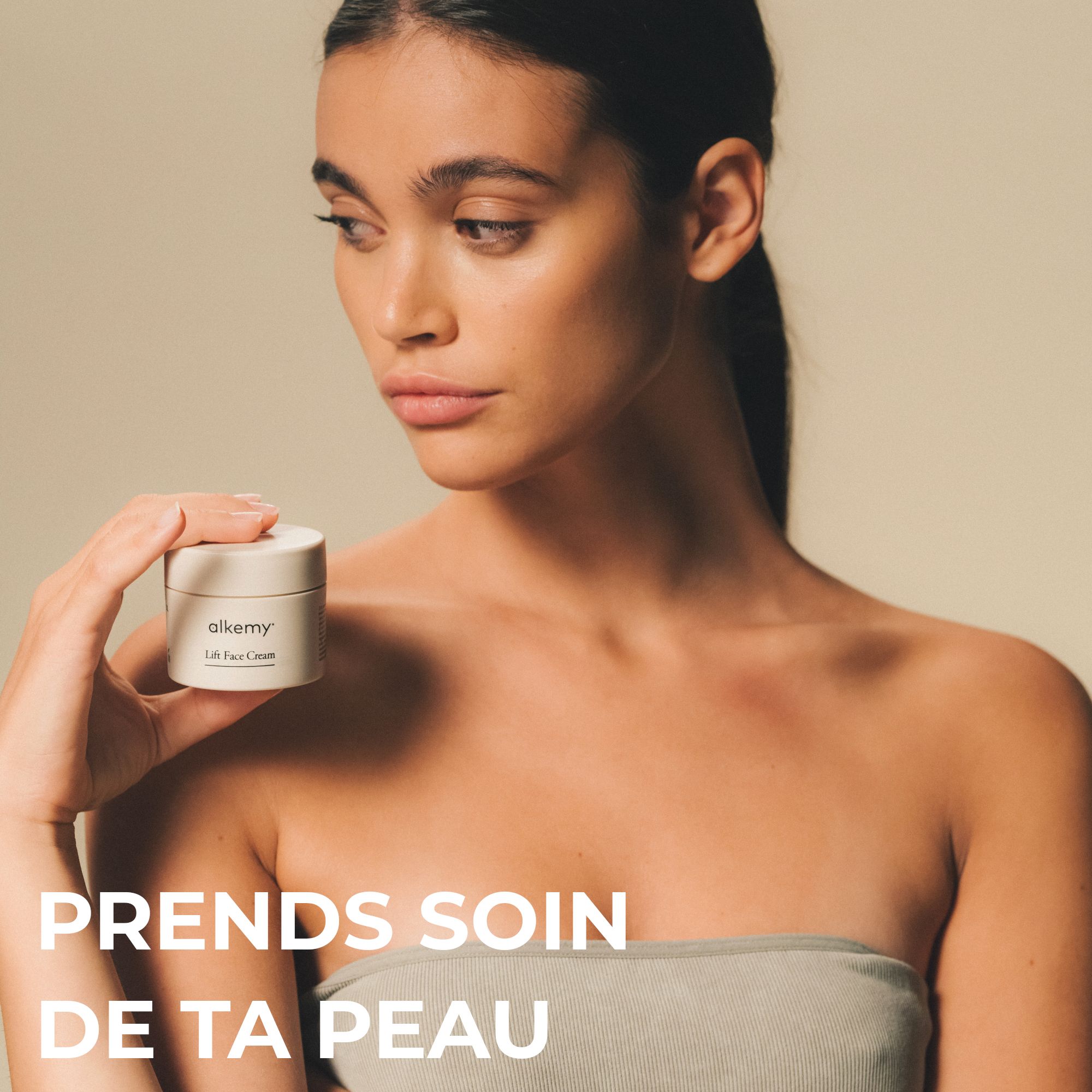 Femme tenant un pot de crème visage Lift Alkemy, texte: Prends soin de ta peau.