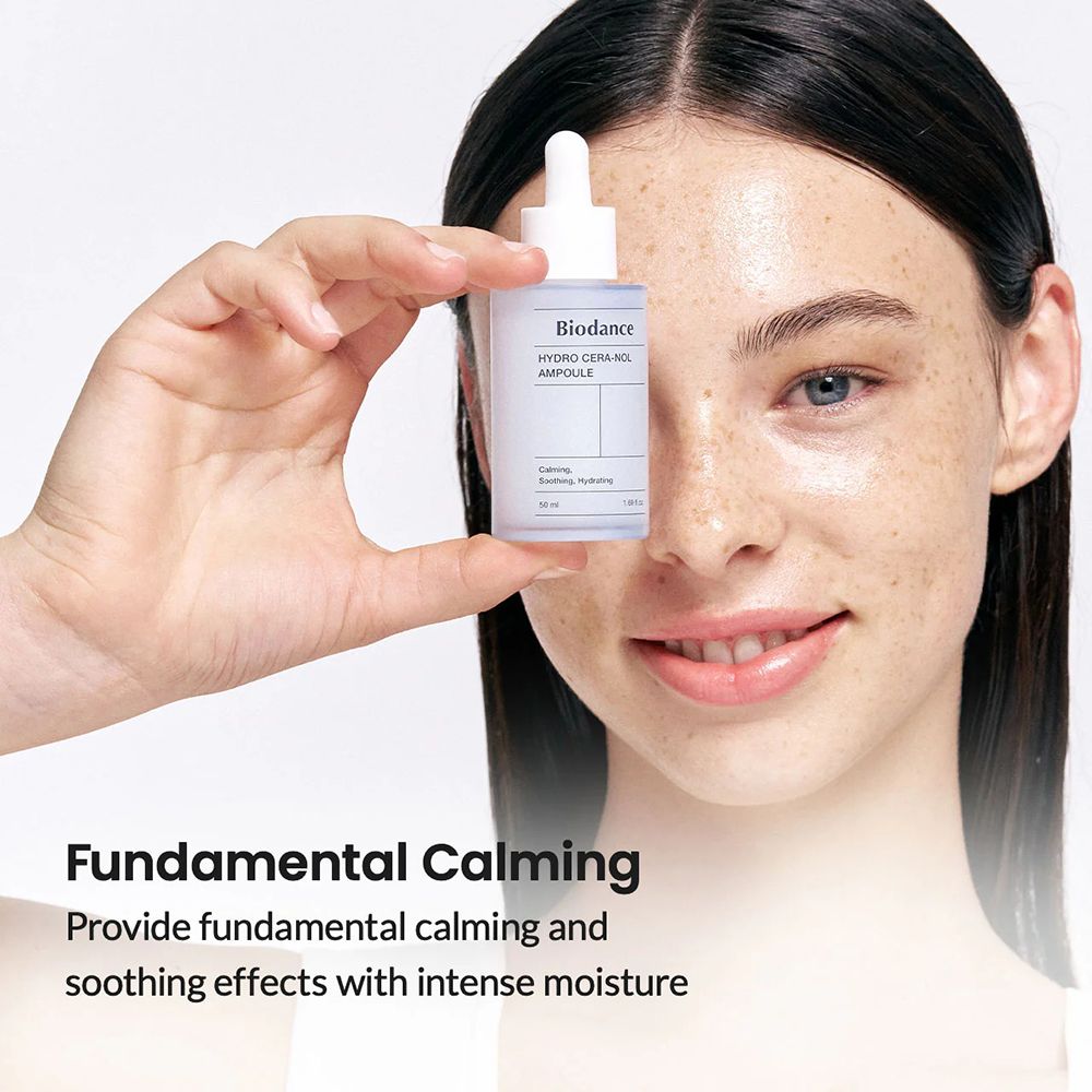 Vrouw houdt een lichtblauw serumflesje met witte dop en pipet vast. Opschrift: Biodance Hydro Cera-nol Ampoule. Tekst: Fundamental Calming.