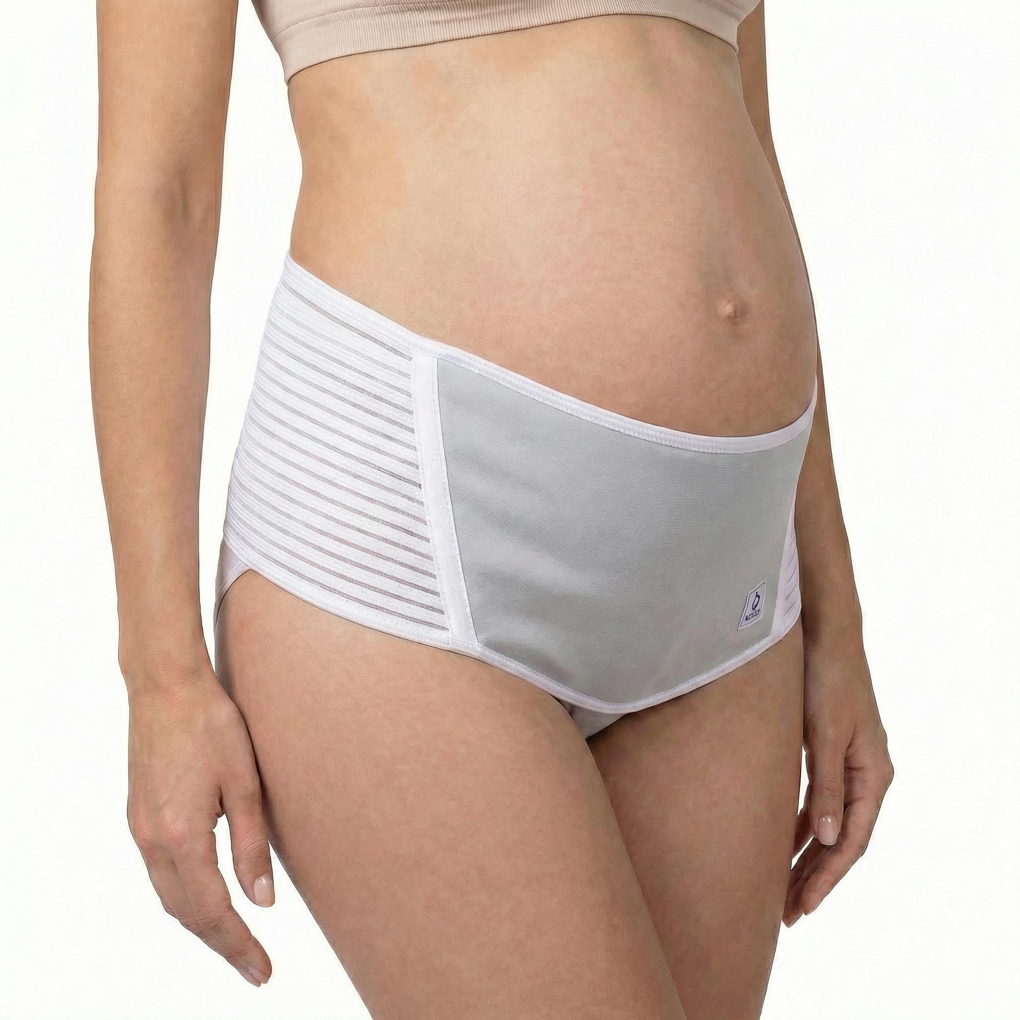 Femme enceinte portant une ceinture abdominale blanche. Partie centrale grise, bandes latérales. Produit positionné sur le ventre.