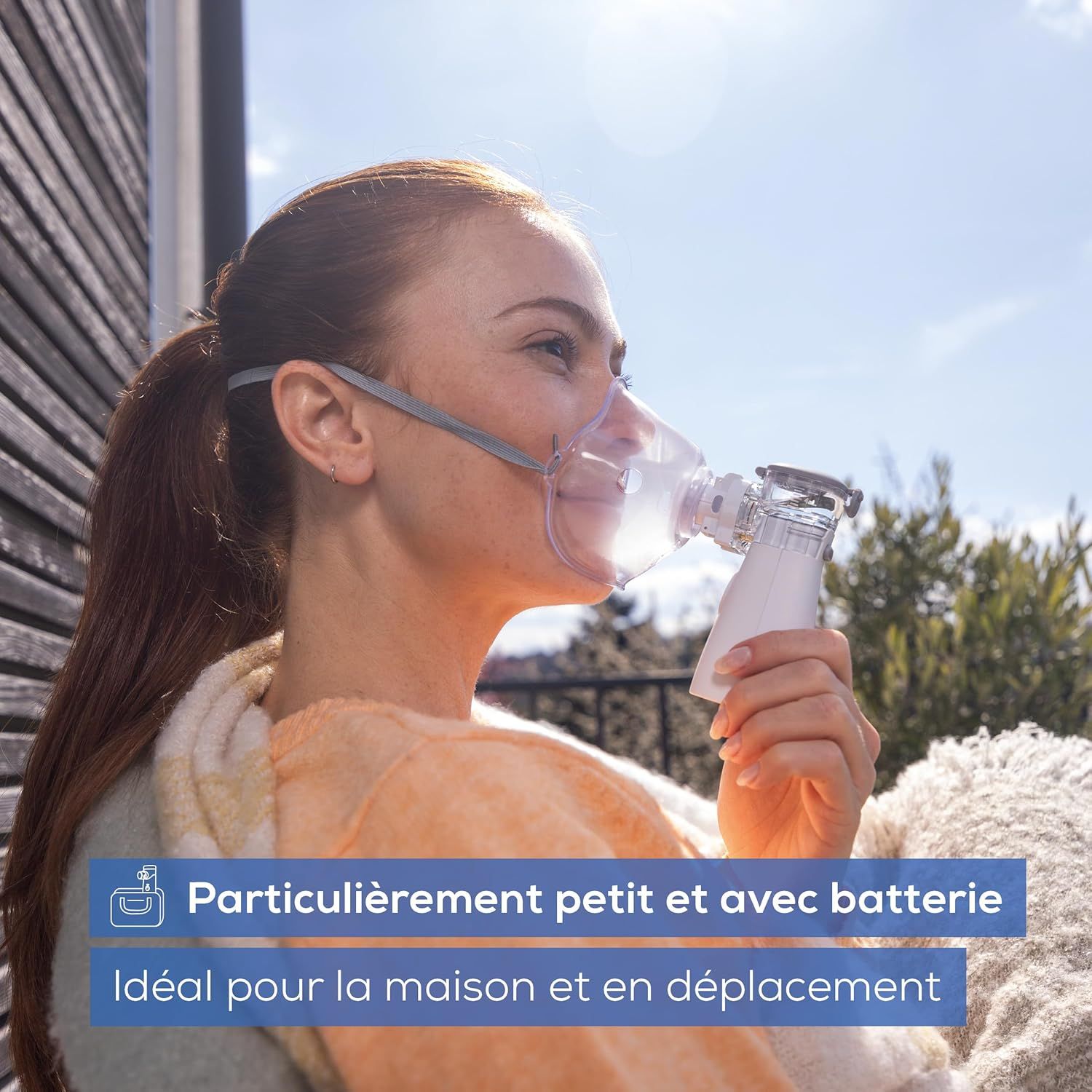 Femme portant un masque d'inhalation et un nébuliseur, portable et à batterie.