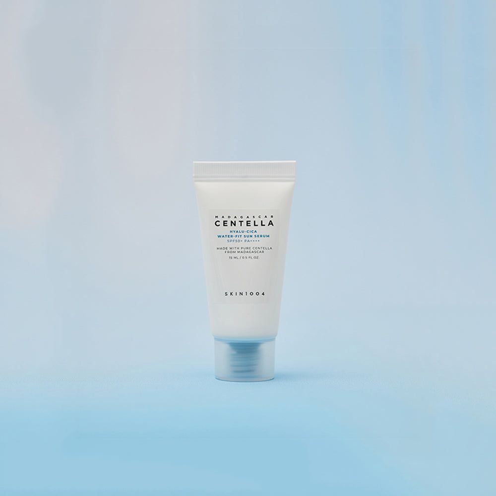 Kleine witte tube met blauwe tekst. Productnaam: CENTELLA Hyalu-Cica Water-Fit Sun Serum SPF50+. Merk: SKIN1004. Blauwe achtergrond.