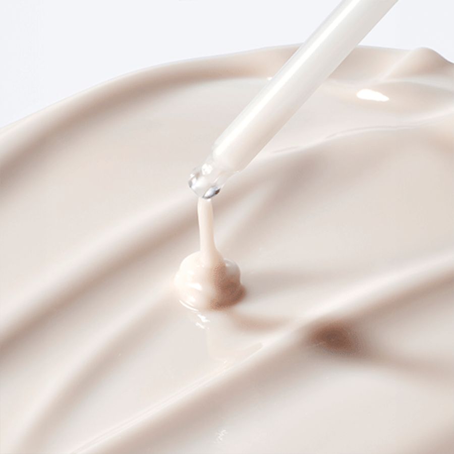 Close-up van crème met pipet. Crèmetextuur, druppels vallen op het oppervlak.