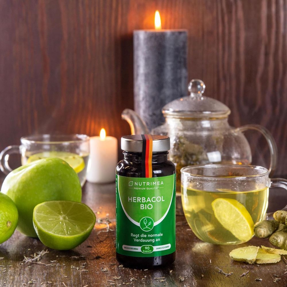 HERBACOL BIO fles, omringd door kaarsen, appels en drankjes. Product in context.