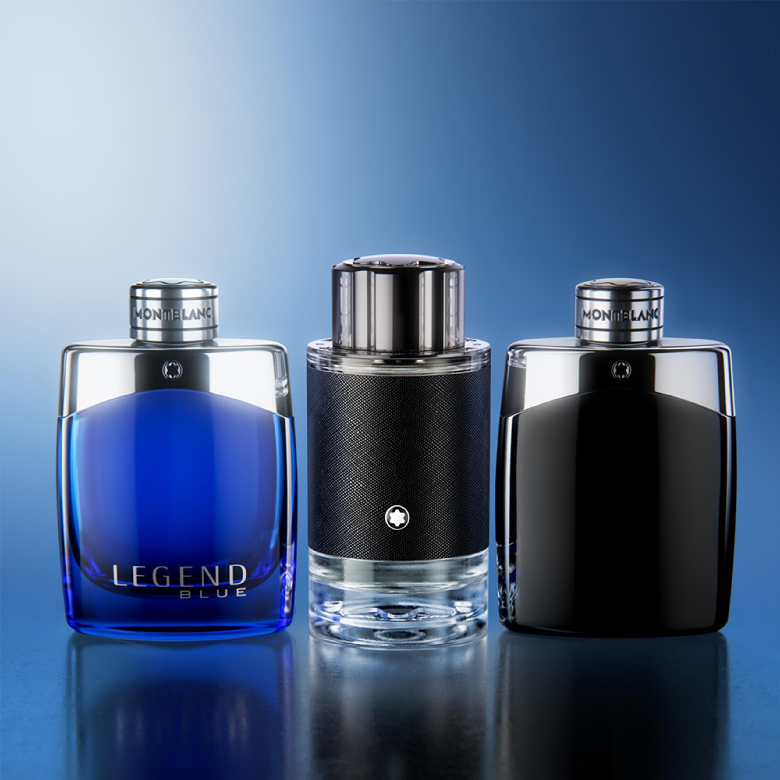 Drie parfumflacons. Blauw, zwart en zwart met textuur. Zilveren doppen. Montblanc-logo.