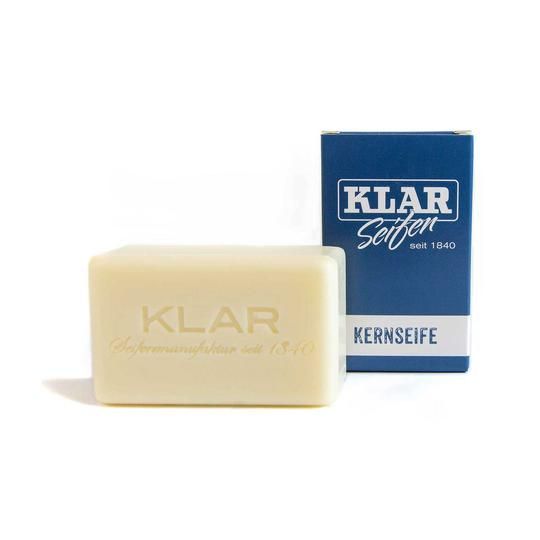 Pain de savon à côté d'un emballage bleu. 'KLAR' estampillé sur le savon.