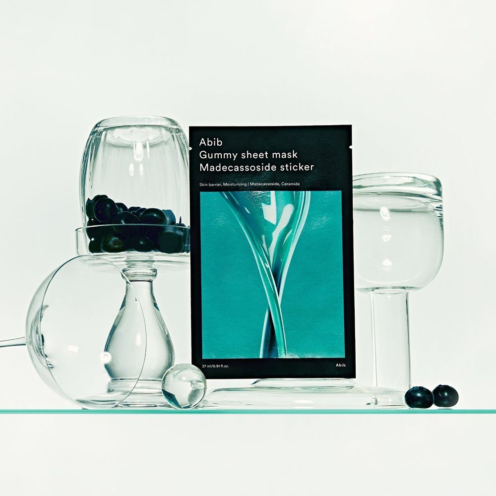 Emballage du produit à côté d'objets en verre. Emballage noir avec nom et ingrédients du produit.