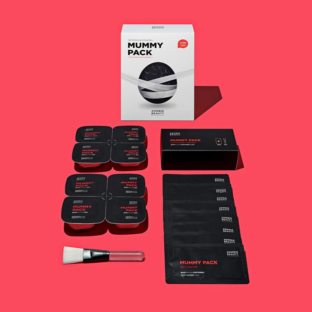 Emballage du produit avec plusieurs emballages individuels, pinceau et boîte noire. Inscription: MUMMY PACK.