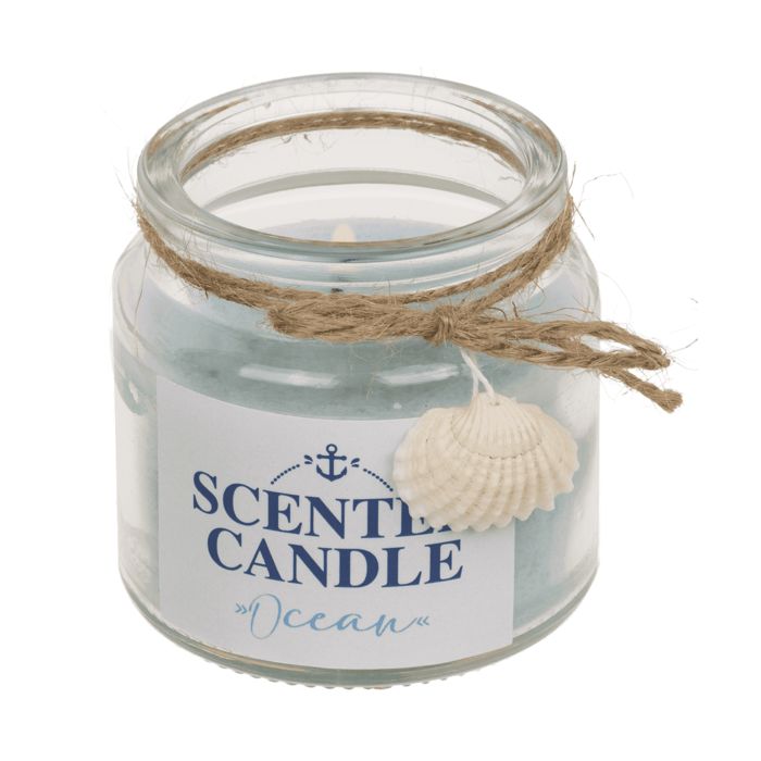 Bougie parfumée en verre. Cire bleue, étiquette avec ancre et texte "SCENTED CANDLE Ocean". Décorée d'un coquillage et cordon.