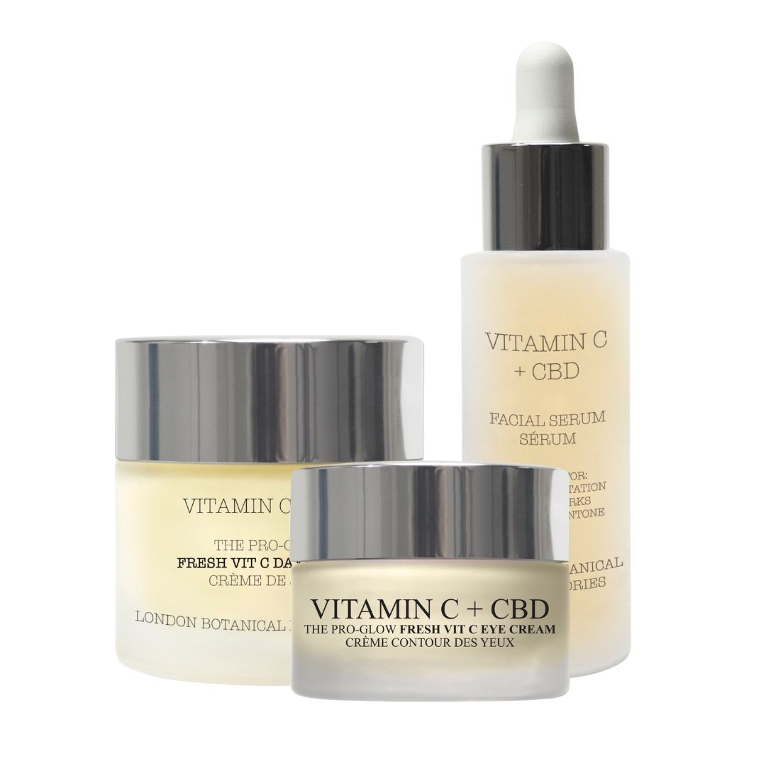 Drie cosmetische producten: dagcrème, oogcrème en serum. Glazen potten met zilveren deksels. Opschrift: Vitamin C + CBD.