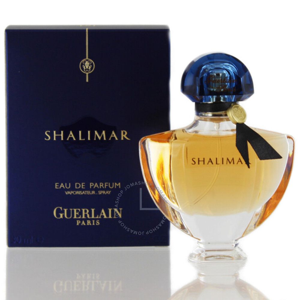 Guerlain Shalimar Eau de Parfum Spray. Flacon bleu et ruban noir. Emballage avec logo et nom du produit.