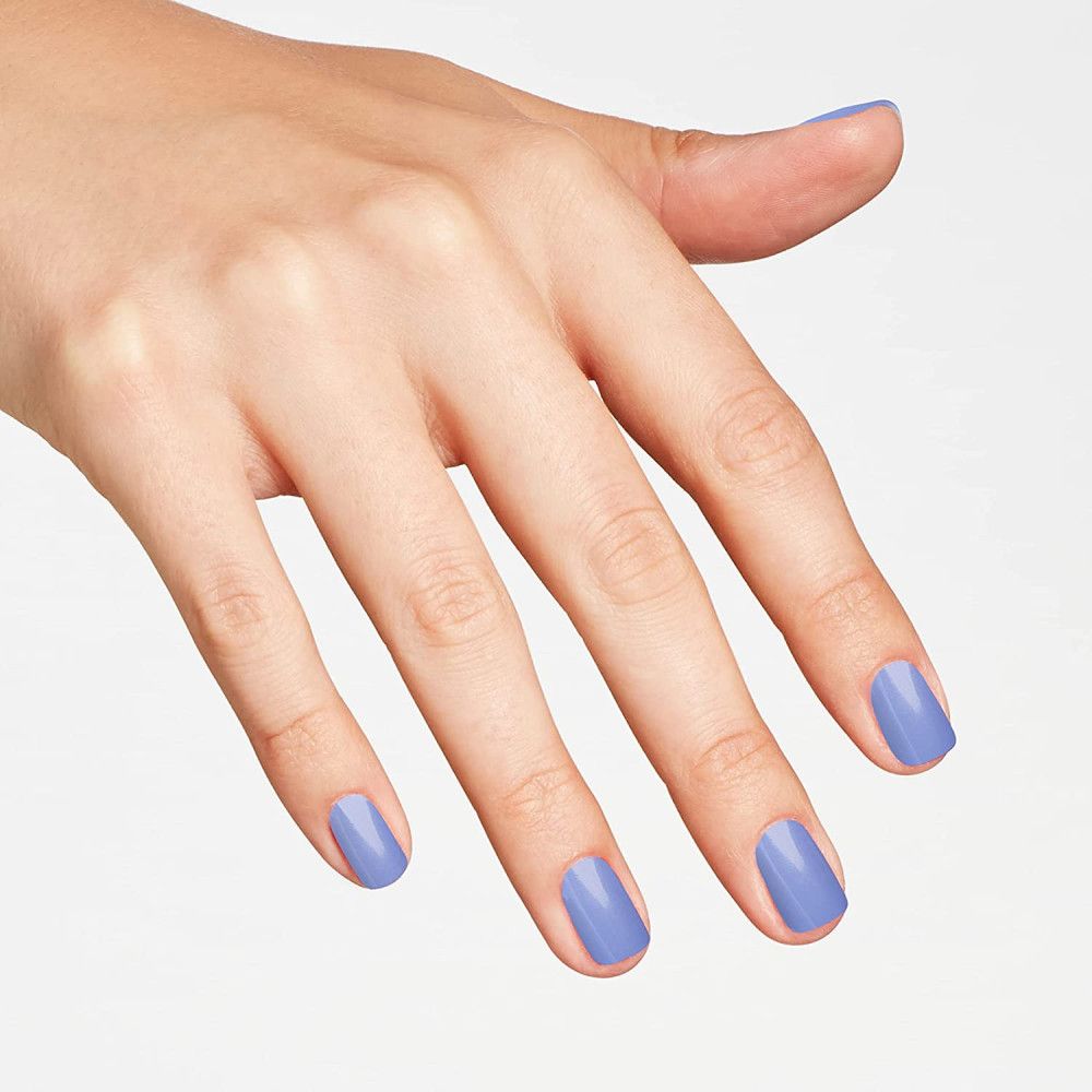 Hand met gelakte nagels in lichtblauw. De nagels zijn kort en vierkant.