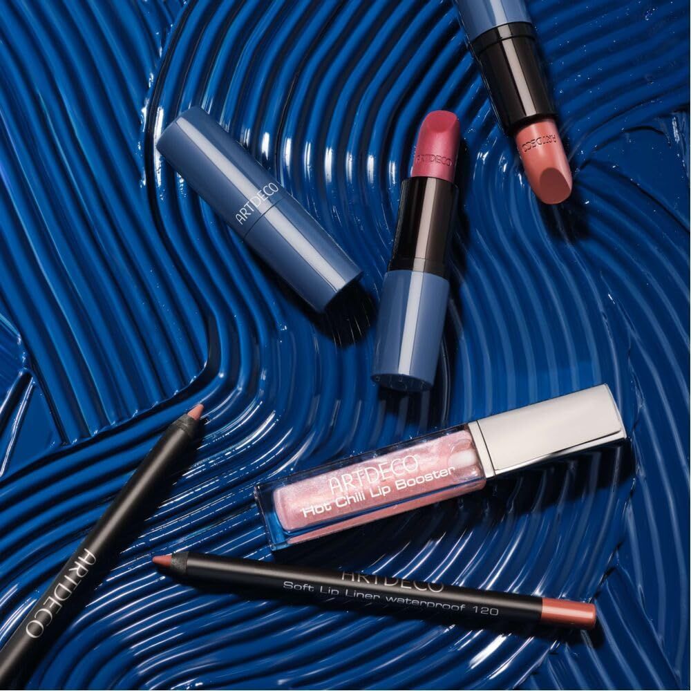 Cosmetische producten op blauwe achtergrond. Artdeco Hot Chili Lip Booster, lippenstiften, lipliners. Producttekst zichtbaar.